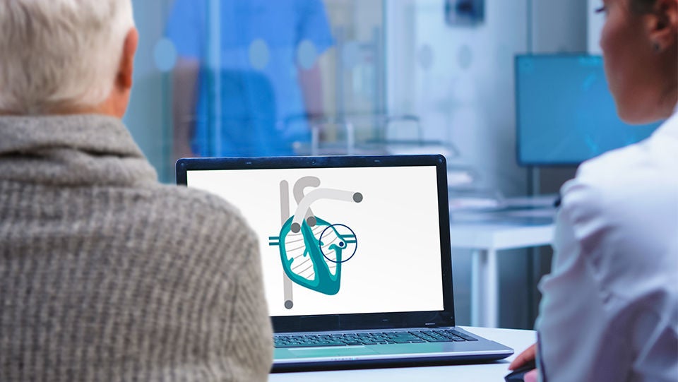 Un profesional sanitario muestra a un paciente un diagrama del corazón en la pantalla del ordenador.