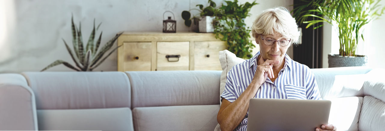 Una mujer de mediana edad leyendo las preguntas frecuentes.